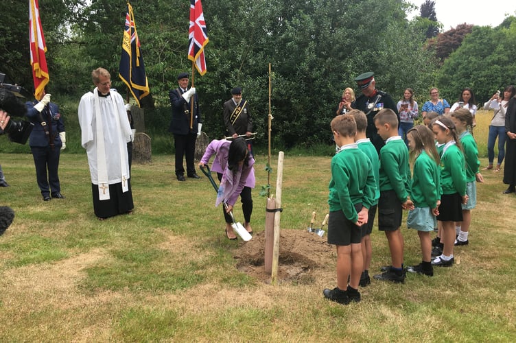 Mrs Anand helping the children plant a maple tree in honour of Canadian troops